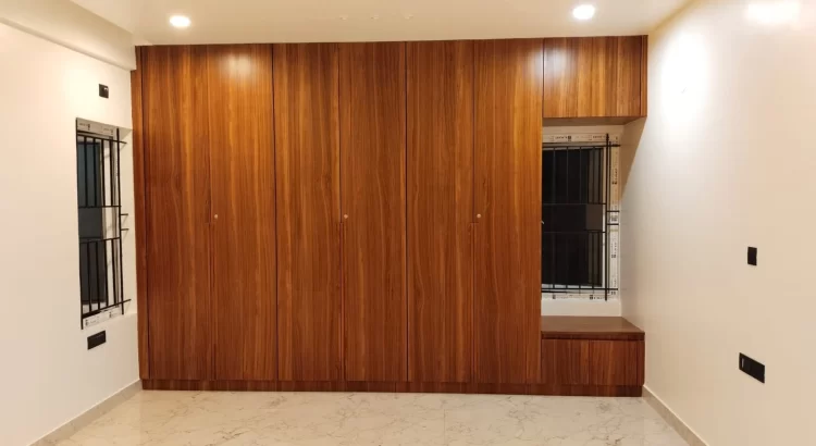 Modern wooden floor-to-ceiling wardrobe by an Interior Design Studio in Rajarajeshwari Nagar.