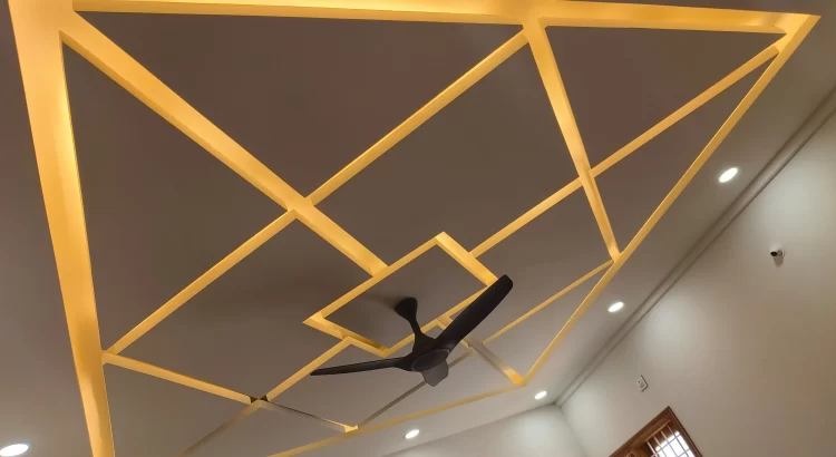Geometric ceiling design with warm LED lighting and a modern ceiling fan.